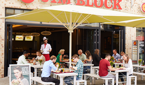 Jim Block Restaurant mit einer Terrasse Jim Block Restaurant mit einer Terrasse wo Gäste unter Sonnenschirmen sitzen und Essen