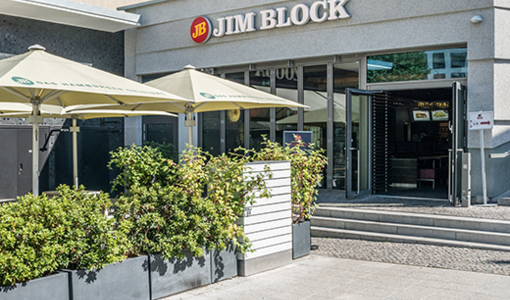 Jim Block Restaurant mit einer Terrasse Jim Block Restaurant mit einer Terrasse mit weißen Sonnenschirmen